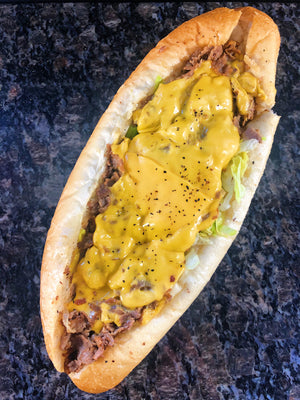  An image of a cheesesteak sandwich. The sandwich features thinly sliced and grilled beef, typically ribeye or sirloin, cooked to perfection. It is served on a long, soft roll and topped with melted cheese, usually provolone or American. The cheesesteak may be garnished with sautéed onions, bell peppers, and mushrooms. The sandwich is mouthwatering and delicious, representing a classic Philadelphia-style cheesesteak.