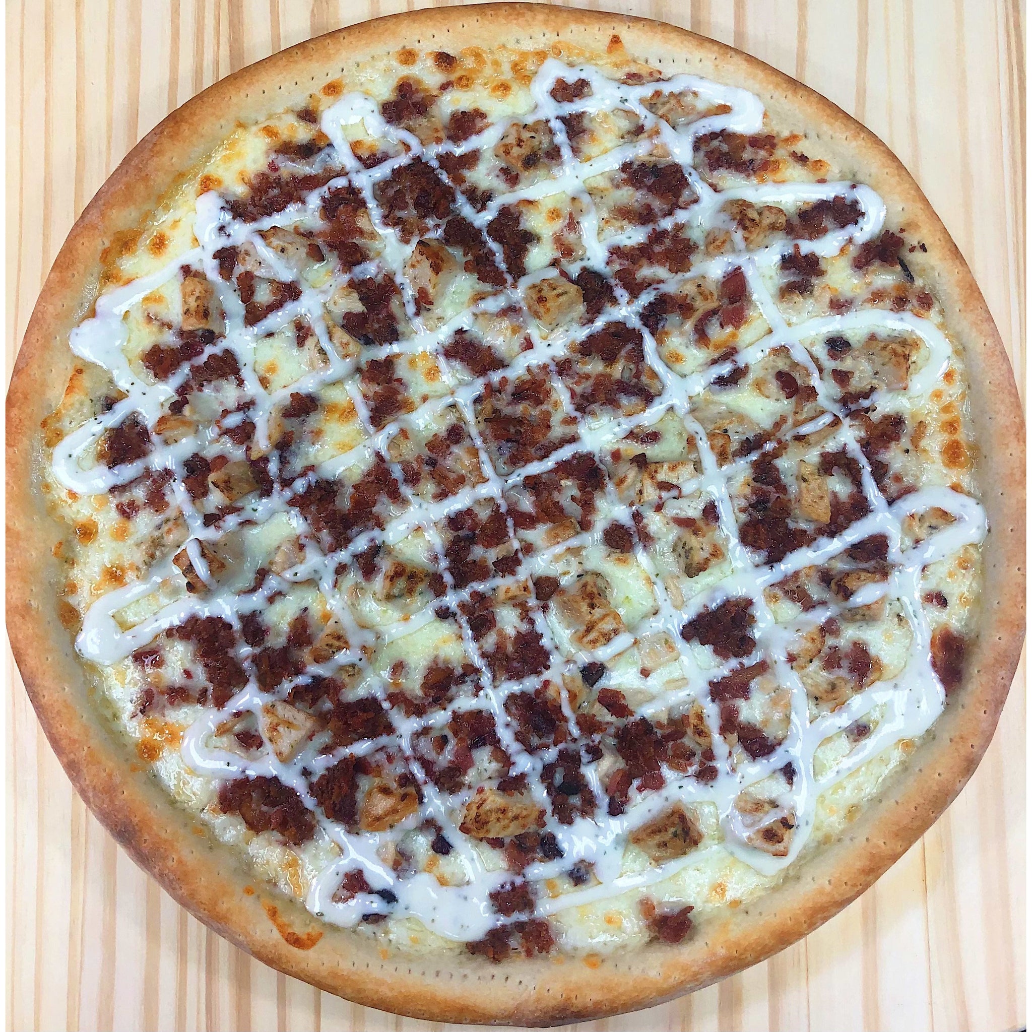 An image of a Chicken Bacon Ranch Pizza. The pizza has a thin and crispy crust topped with a creamy ranch sauce. It is generously layered with seasoned chicken pieces, crispy bacon strips, and melted cheese. The pizza is garnished with fresh chopped tomatoes and a sprinkle of herbs, presenting a delicious combination of flavors. It is a visually appealing and appetizing pizza.
