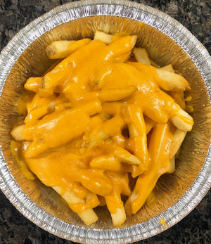 An image of cheesy fries. The fries are crispy and golden brown, served in a pile. They are generously topped with melted cheese, creating a gooey and savory layer. The cheesy fries are garnished with chopped green onions, adding a pop of color. This indulgent snack is visually appealing and perfect for cheese lovers.