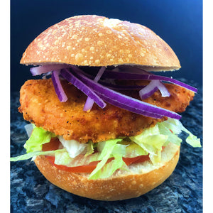 An image of a breaded chicken sandwich. The sandwich features a crispy breaded chicken fillet, fried to a golden-brown color. The chicken is placed on a soft bun and topped with lettuce, tomato, and mayonnaise. The sandwich is garnished with a pickle and served with a side of fries, creating an appetizing and satisfying meal.
